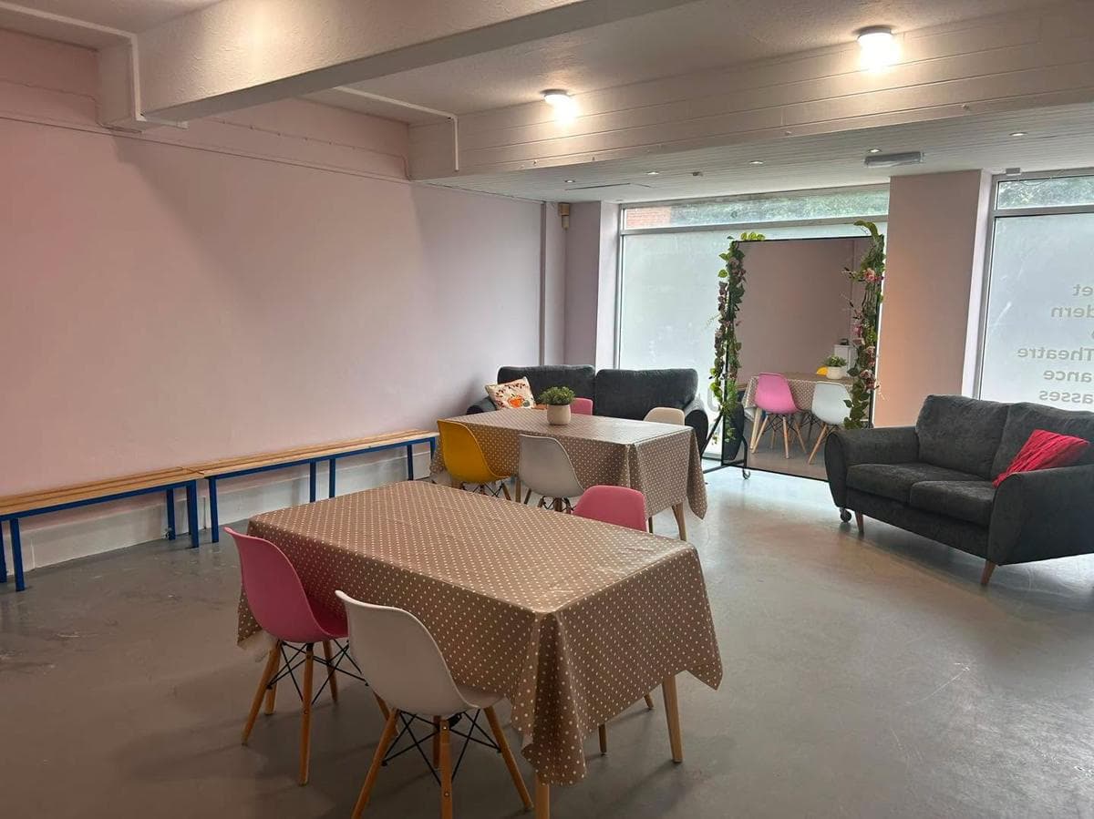 The parents' waiting area with sofas, tables and a floral garland
