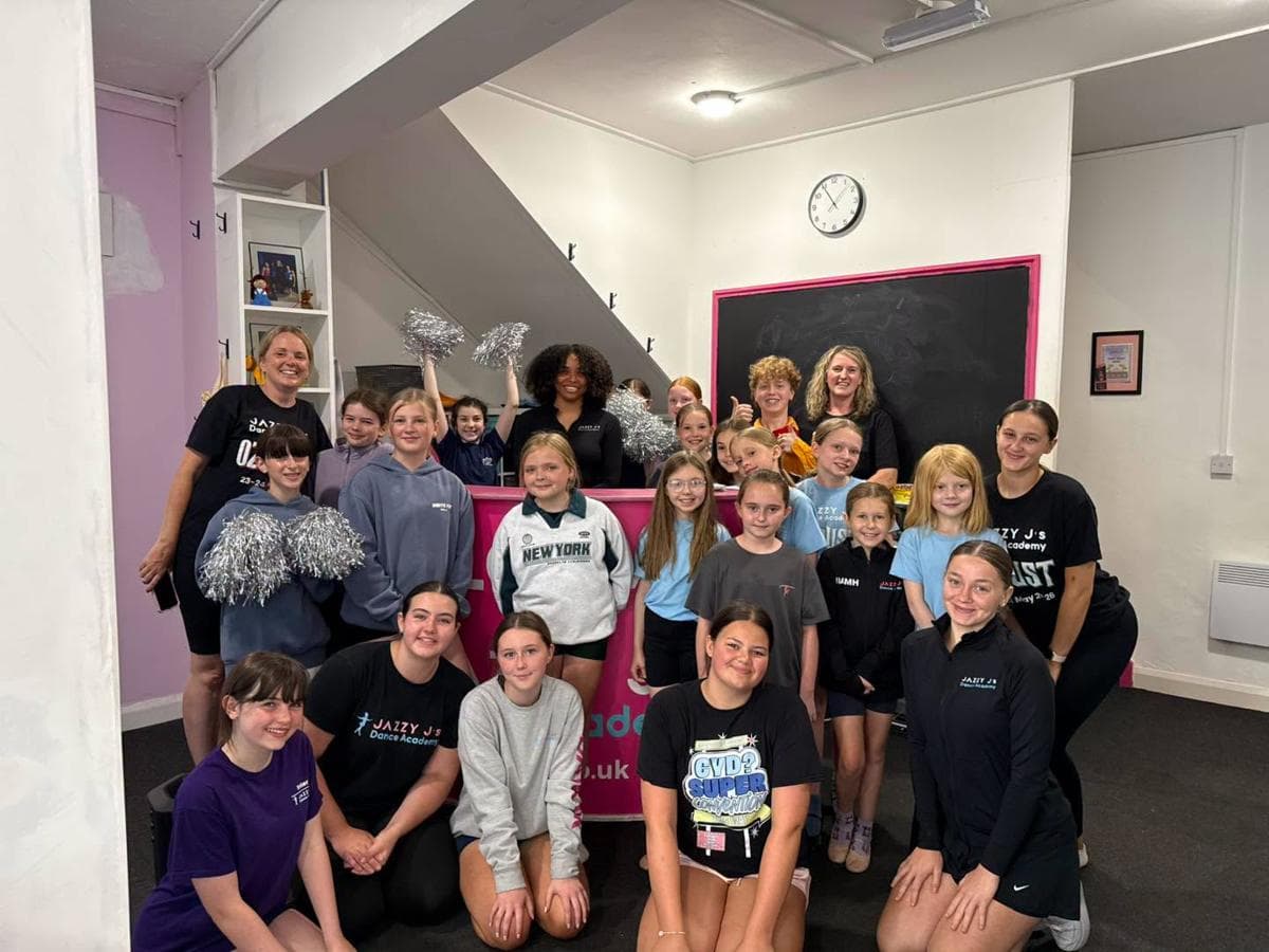 Pupils and teachers gathered by the pink reception desk
