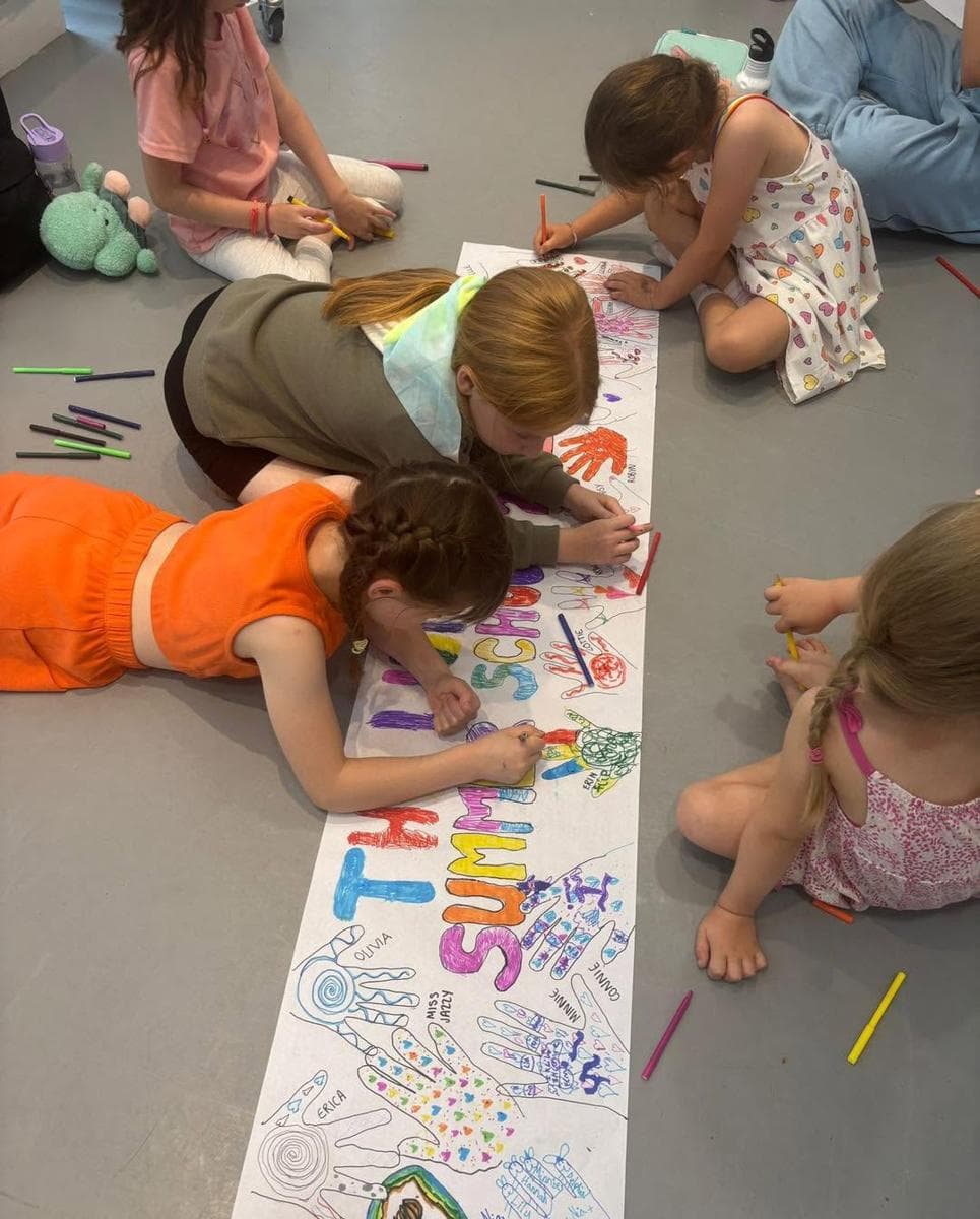 Children painting a giant banner on the studio floor