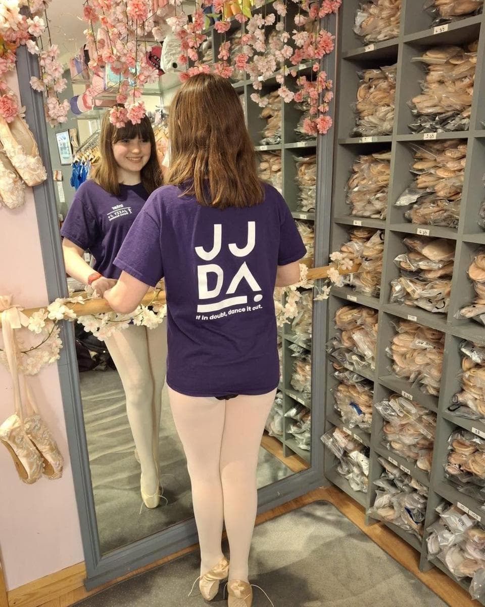 A pupil by the pointe shoe wall with blossom garland