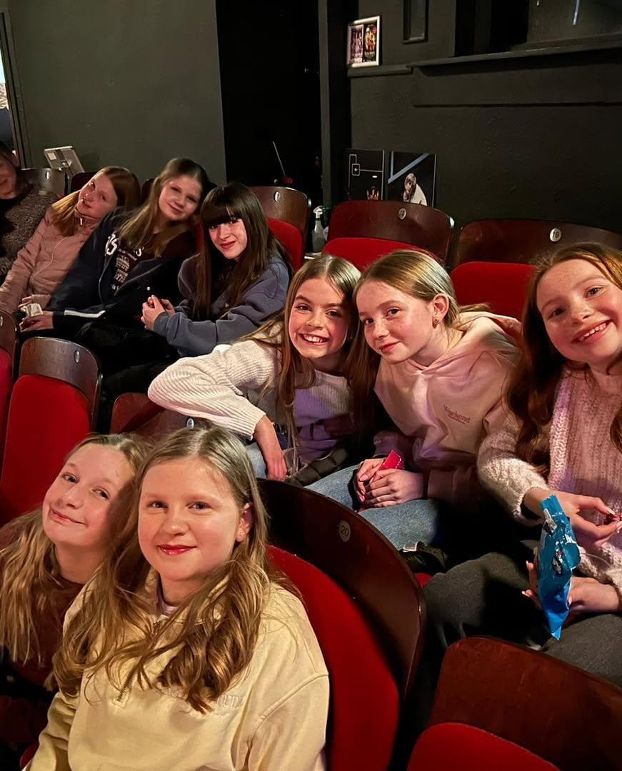 Pupils in red theatre seats on a theatre trip