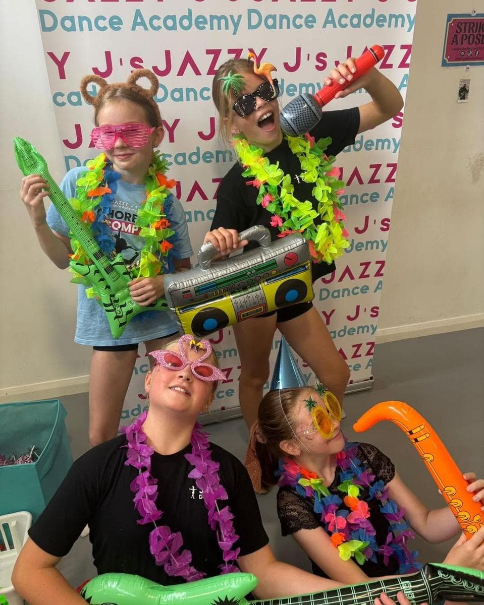 Pupils with inflatable guitars and leis