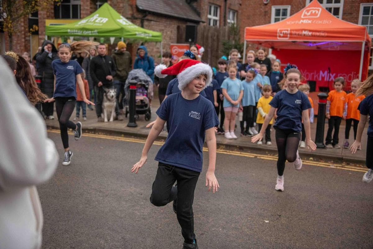 A dancer in a Santa hat performing in the street