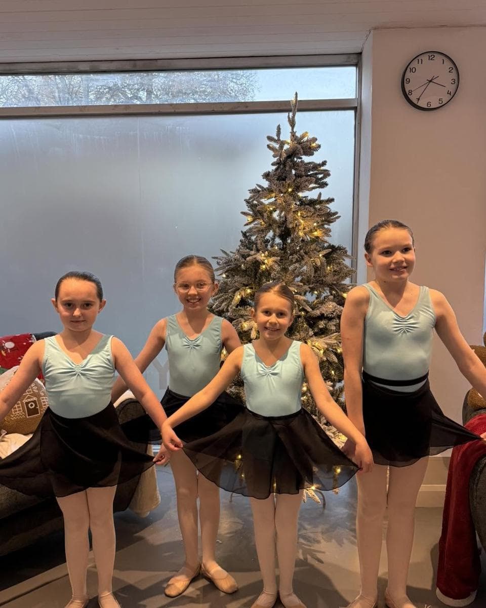 Young pupils in turquoise and tutus by the Christmas tree