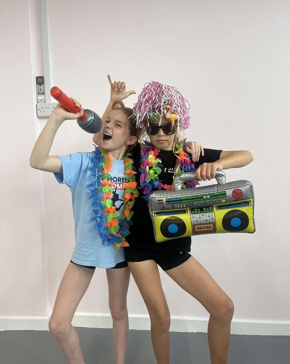Two girls with a toy boombox and microphone