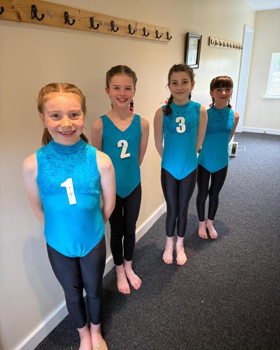 Four pupils in turquoise leotards with numbers