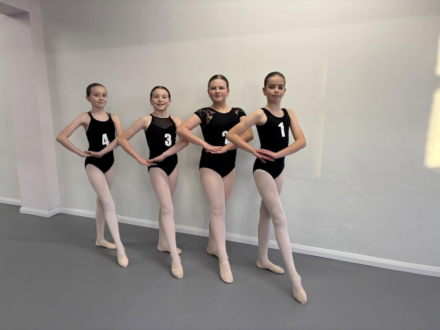 Four ballet pupils in black leotards after completing their Royal Ballet School Affiliate assessment