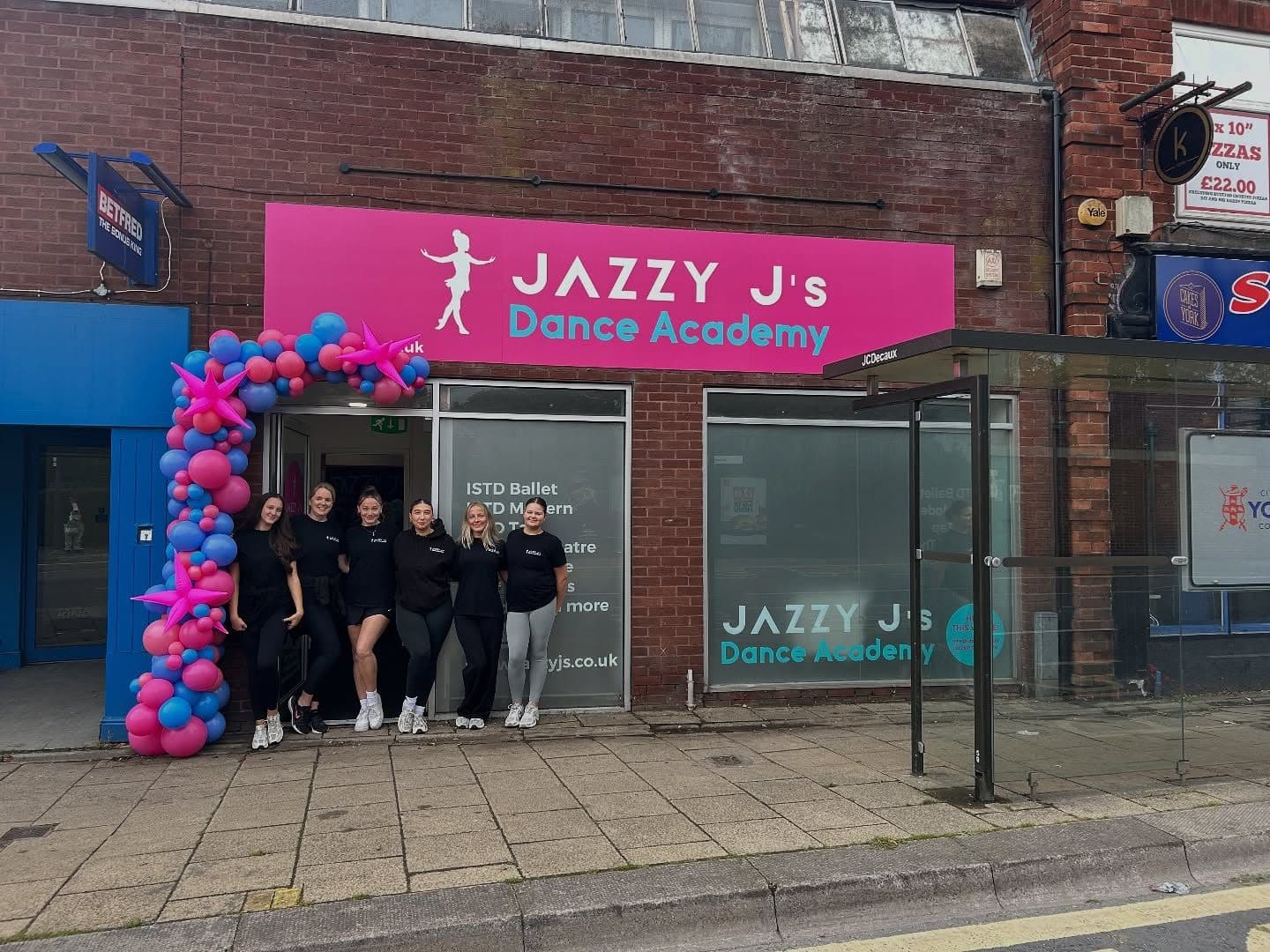 The pink Jazzy J's shopfront on Front Street with a balloon arch and the teaching team outside